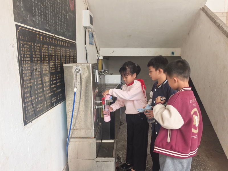 图8：越秀区联动热心企业为乐民镇中小学校全覆盖安装饮水机和热水器，学生在纯水机前打水.jpg